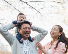kid on dads shoulders with mom