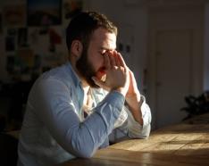 man with folded hands in stress mode