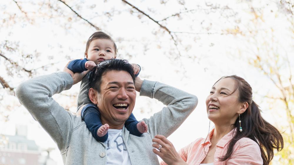 kid on dads shoulders with mom