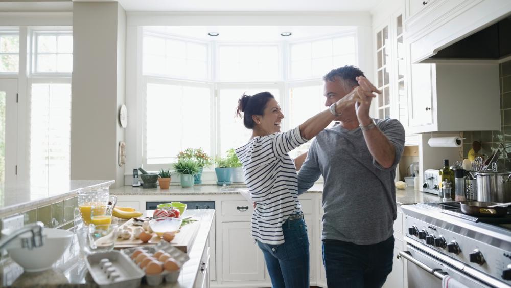 couple dancing in kitchen while making dinner