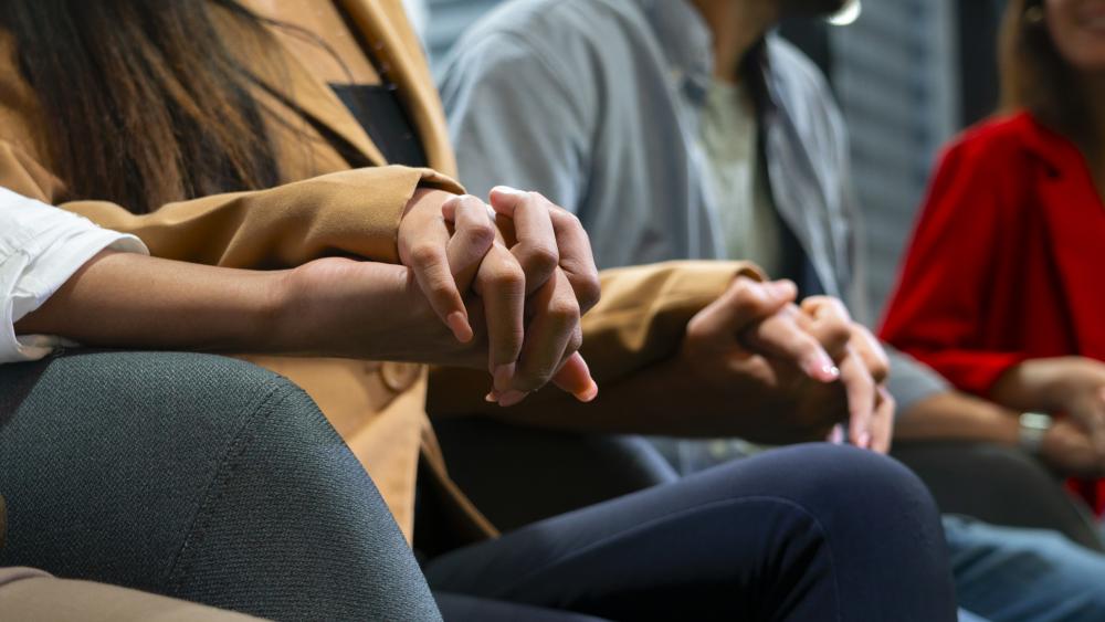 People holding hands in a support group