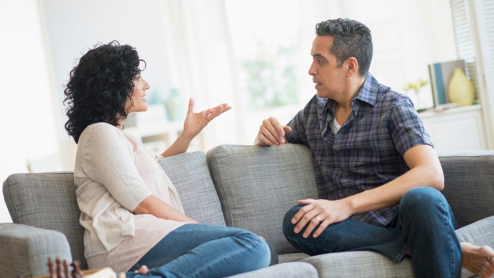 couple sitting on couch discussing something