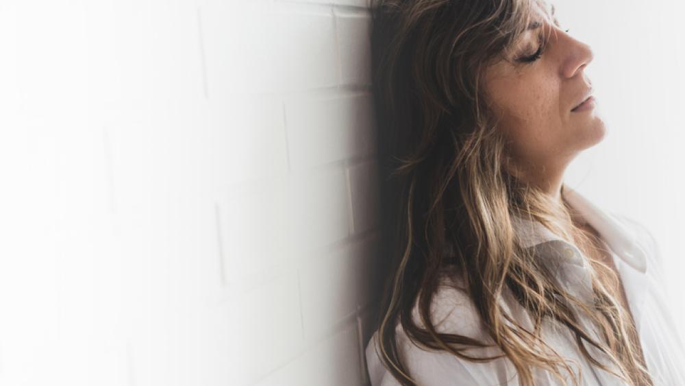 Woman leaning on wall frustrated