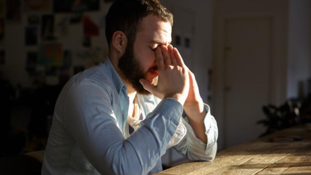 man with folded hands in stress mode