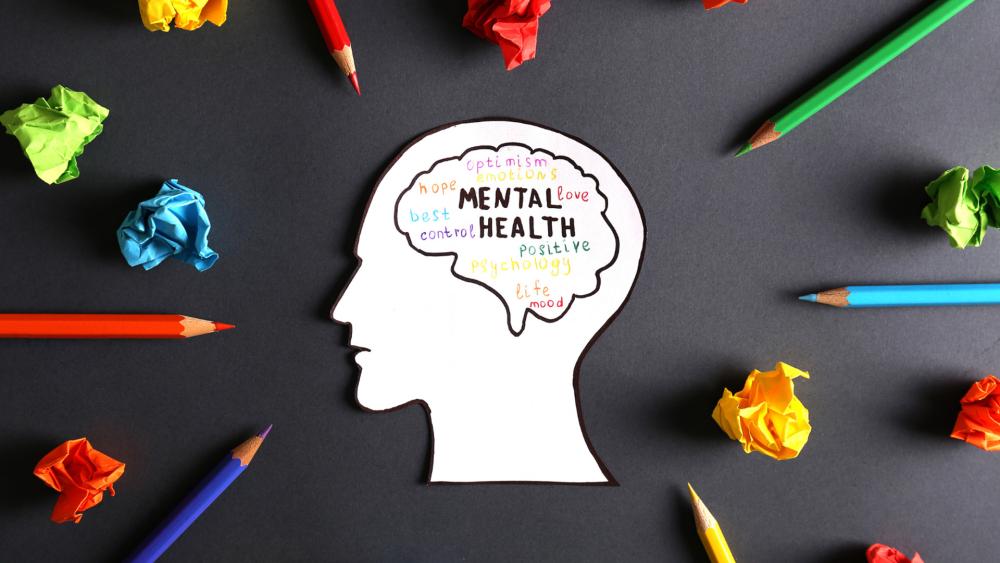 Crumpled pieces of paper and pencils surround a paper head