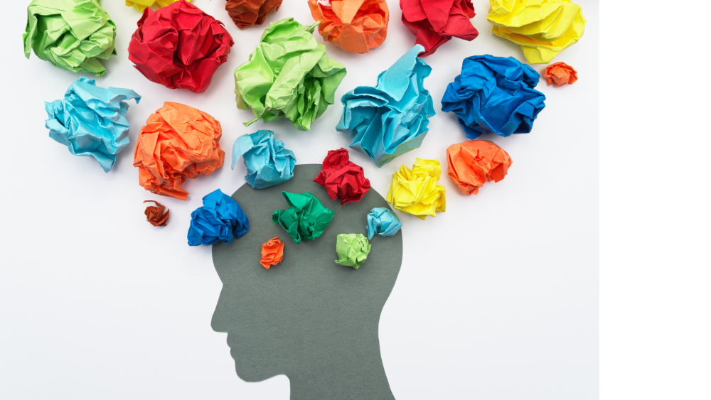 Crumpled colored paper coming out of an outline of a human head