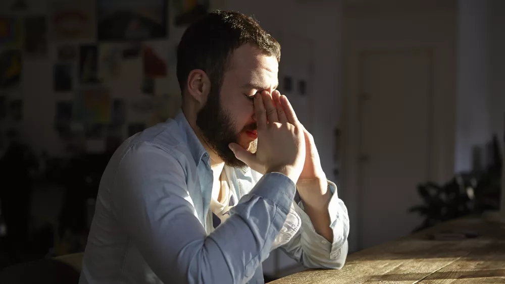 man with folded hands in stress mode